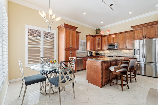 kitchen featuring backsplash, brown cabinetry, appliances with stainless steel finishes, and a kitchen island