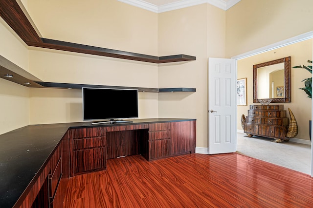 unfurnished office featuring baseboards, dark wood-type flooring, and crown molding