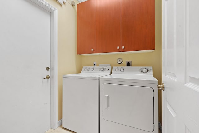 washroom with cabinet space and separate washer and dryer