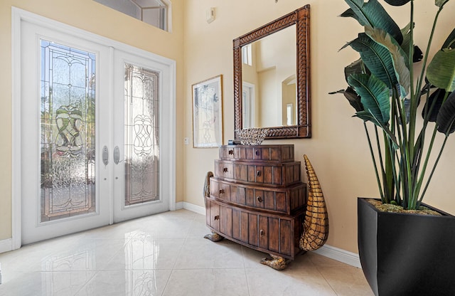 tiled foyer entrance featuring french doors and baseboards