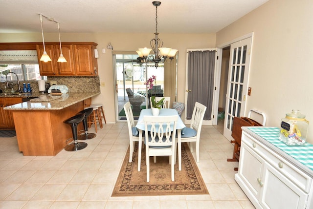 557 SE Seahouse Dr, Port Saint Lucie, FL 34983 - dining area featuring a healthy amount of sunlight, light tile patterned floors, and a notable chandelier