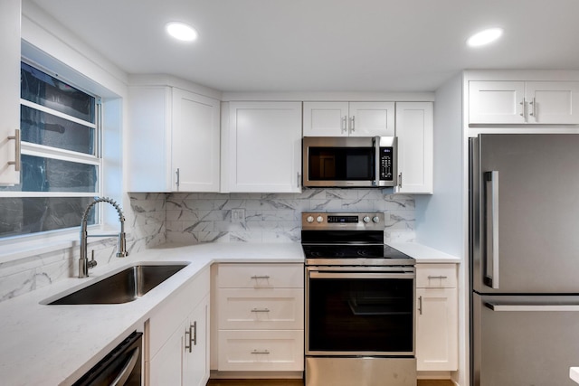 308 Golfview Rd Unit Ph02, North Palm Beach, FL 33408 - kitchen with white cabinets, a sink, tasteful backsplash, and appliances with stainless steel finishes