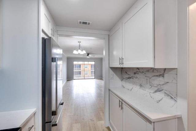 308 Golfview Rd Unit Ph02, North Palm Beach, FL 33408 - corridor with light wood-type flooring, visible vents, and a notable chandelier