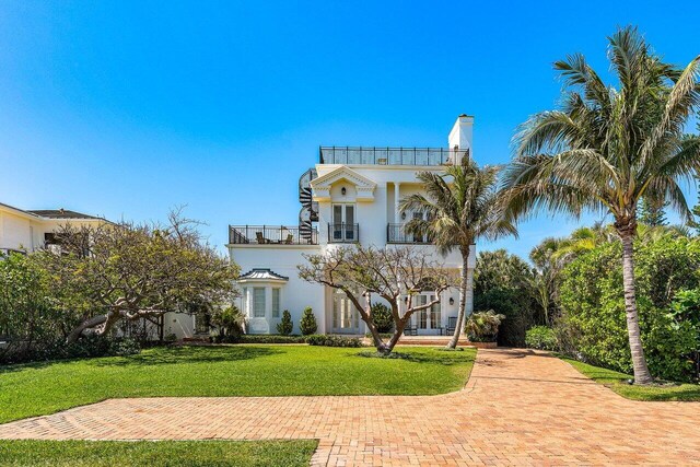 6080 Old Ocean Blvd, Ocean Ridge, FL 33435 - view of front of property with a balcony, french doors, a front yard, stucco siding, and a chimney