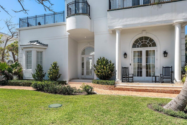 6080 Old Ocean Blvd, Ocean Ridge, FL 33435 - entrance to property featuring french doors, a lawn, stucco siding, and a balcony