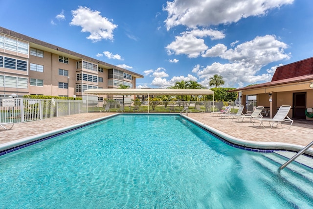 pool with fence and a patio