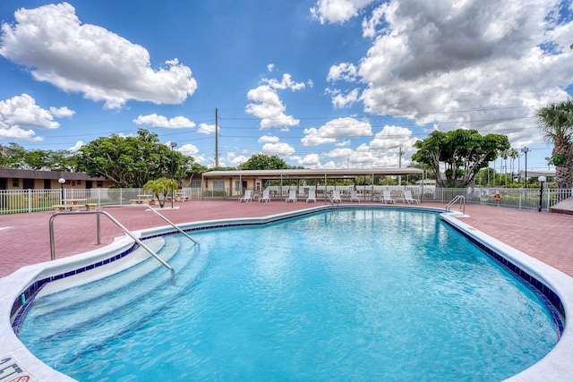 pool featuring fence and a patio area