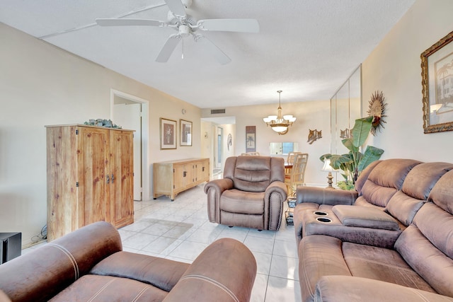 living area with light tile patterned floors, visible vents, and ceiling fan with notable chandelier