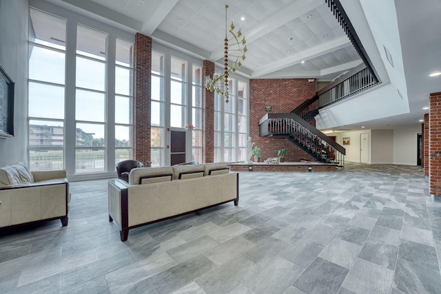 living room featuring a high ceiling, brick wall, and beamed ceiling