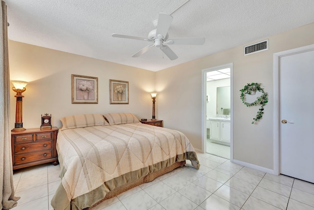 bedroom with light tile patterned flooring, a textured ceiling, baseboards, visible vents, and ceiling fan