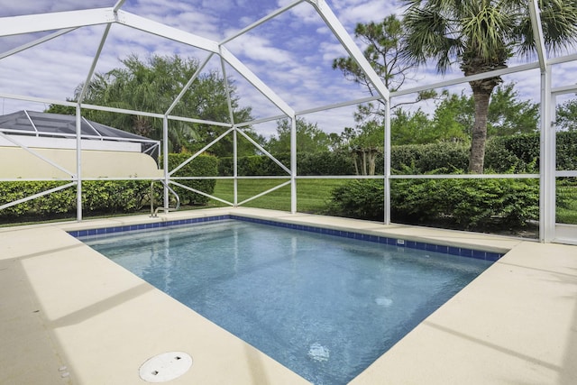 outdoor pool with glass enclosure and a patio