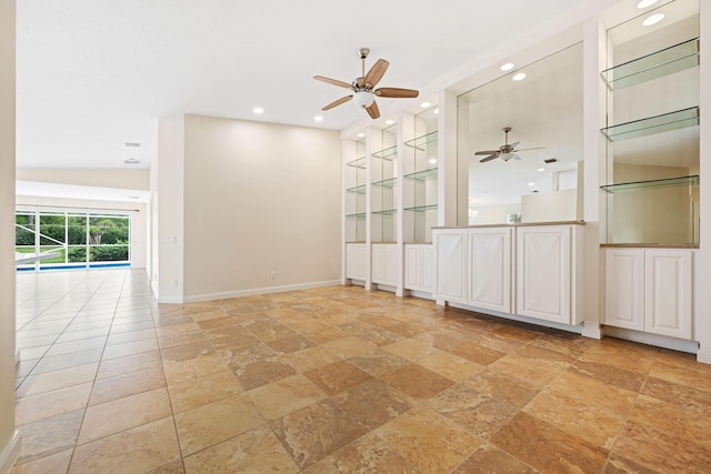spare room with ceiling fan, built in shelves, recessed lighting, baseboards, and stone tile flooring
