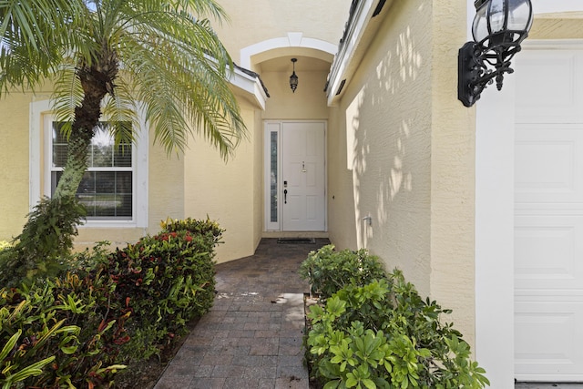 154 Berenger Walk, Royal Palm Beach, FL 33414 - doorway to property with stucco siding and a garage