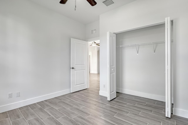 311 Ocean Pkwy, Boynton Beach, FL 33435 - unfurnished bedroom featuring baseboards, visible vents, wood tiled floor, ceiling fan, and a closet
