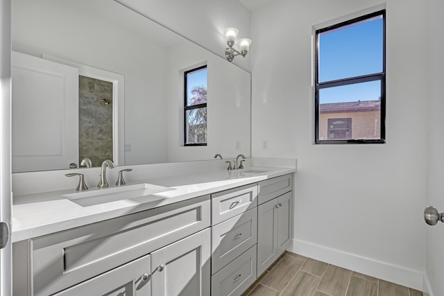 311 Ocean Pkwy, Boynton Beach, FL 33435 - bathroom with double vanity, a tile shower, baseboards, and a sink