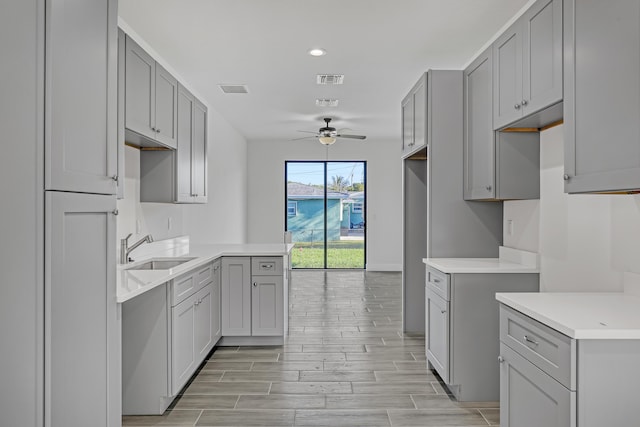 311 Ocean Pkwy, Boynton Beach, FL 33435 - kitchen featuring wood finish floors, gray cabinets, a ceiling fan, and a sink