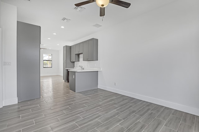 311 Ocean Pkwy, Boynton Beach, FL 33435 - unfurnished living room with a sink, visible vents, wood tiled floor, and a ceiling fan
