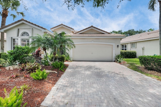 13594 Morocca Lake Ln, Delray Beach, FL 33446 - view of front facade featuring decorative driveway, a garage, stucco siding, and a tile roof