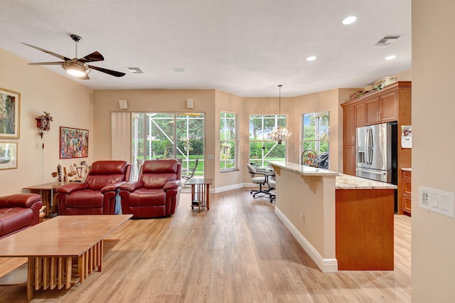 living room featuring visible vents, plenty of natural light, and light wood finished floors