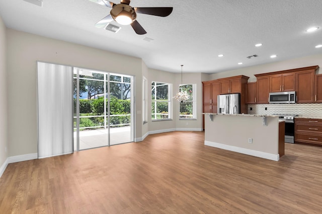 13594 Morocca Lake Ln, Delray Beach, FL 33446 - kitchen with appliances with stainless steel finishes, baseboards, decorative backsplash, wood finished floors, and recessed lighting