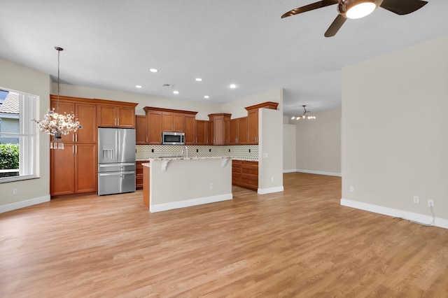 13594 Morocca Lake Ln, Delray Beach, FL 33446 - kitchen with stainless steel appliances, a chandelier, open floor plan, a kitchen breakfast bar, and recessed lighting