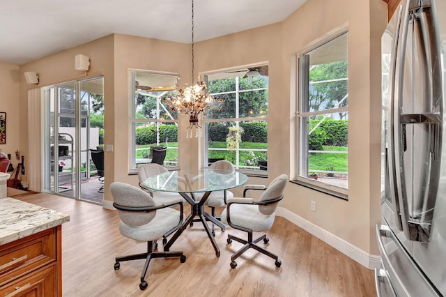 dining space with a wealth of natural light and light wood-style flooring