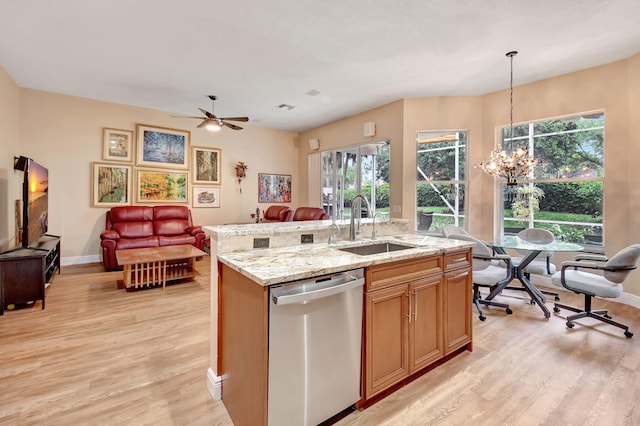 kitchen with open floor plan, light wood-style flooring, dishwasher, and a sink