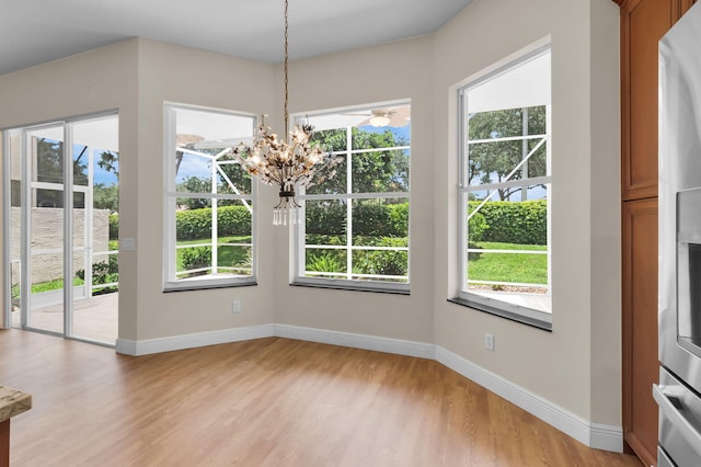 13594 Morocca Lake Ln, Delray Beach, FL 33446 - unfurnished dining area featuring light wood-style flooring, a chandelier, and baseboards