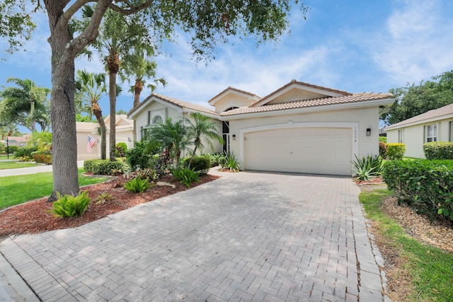 13594 Morocca Lake Ln, Delray Beach, FL 33446 - mediterranean / spanish-style home with an attached garage, stucco siding, decorative driveway, and a tile roof