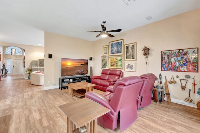 living room with light wood finished floors, visible vents, baseboards, and ceiling fan
