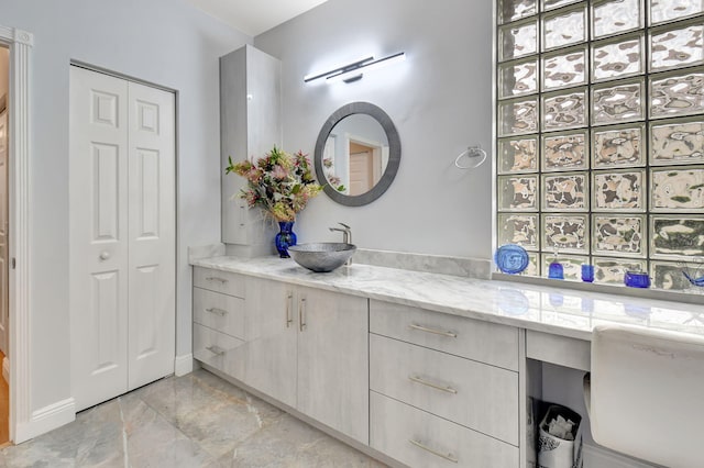 full bath featuring vanity, a closet, and marble finish floor