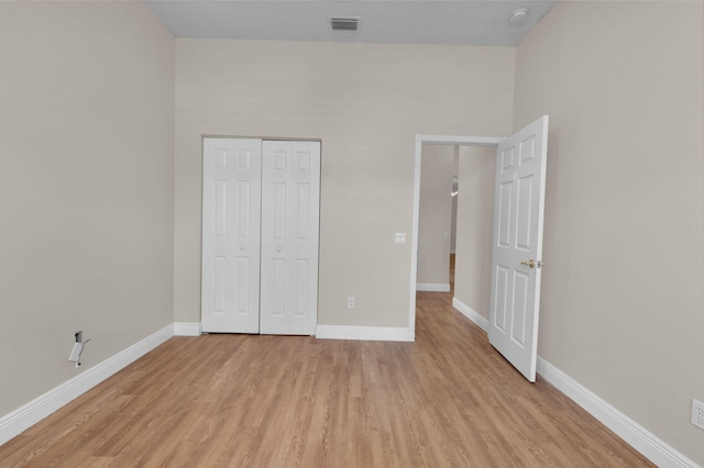 13594 Morocca Lake Ln, Delray Beach, FL 33446 - unfurnished bedroom with light wood-style flooring, baseboards, and a closet