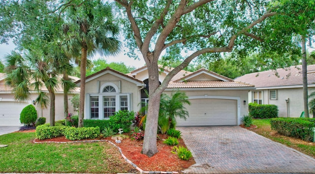 13594 Morocca Lake Ln, Delray Beach, FL 33446 - ranch-style home featuring a garage, stucco siding, decorative driveway, and a tiled roof