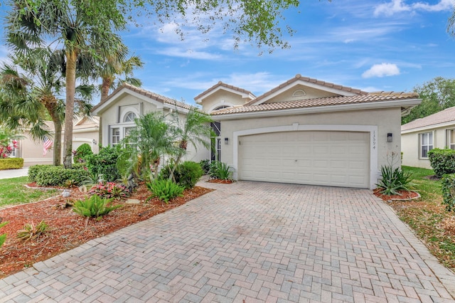 13594 Morocca Lake Ln, Delray Beach, FL 33446 - mediterranean / spanish-style home featuring decorative driveway, stucco siding, and an attached garage