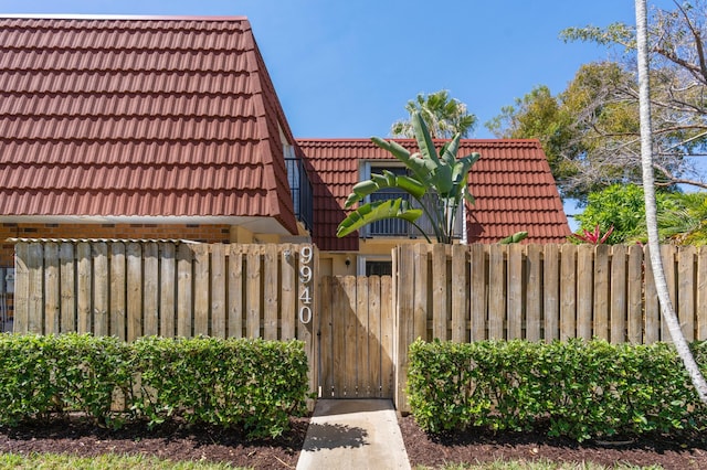 9940 NW 6th Pl, Plantation, FL 33324 - exterior space featuring fence, a tiled roof, and a gate