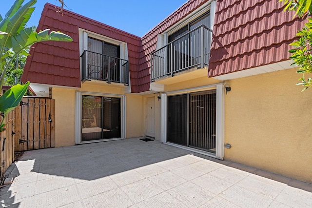 9940 NW 6th Pl, Plantation, FL 33324 - back of property with a tiled roof, mansard roof, a patio area, a balcony, and stucco siding