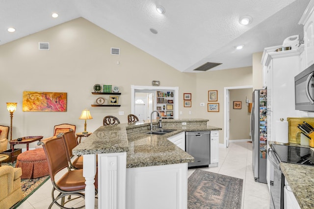 6106 Vista Linda Ln, Boca Raton, FL 33433 - kitchen with a kitchen breakfast bar, visible vents, a sink, lofted ceiling, and stainless steel appliances