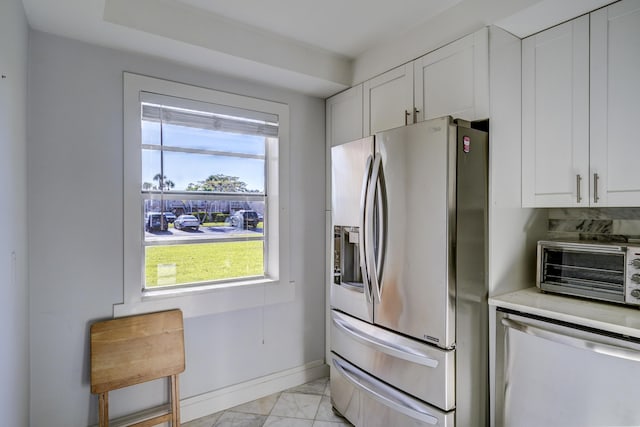 140 Lake Meryl Dr Unit 133, West Palm Beach, FL 33411 - kitchen with stainless steel fridge, dishwasher, light marble finish flooring, and white cabinets