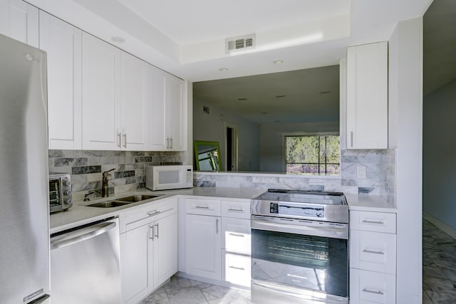 140 Lake Meryl Dr Unit 133, West Palm Beach, FL 33411 - kitchen featuring appliances with stainless steel finishes, a sink, light marble finish flooring, light countertops, and recessed lighting