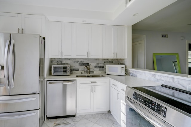 140 Lake Meryl Dr Unit 133, West Palm Beach, FL 33411 - kitchen with stainless steel appliances, a sink, light marble finish flooring, light countertops, and white cabinets