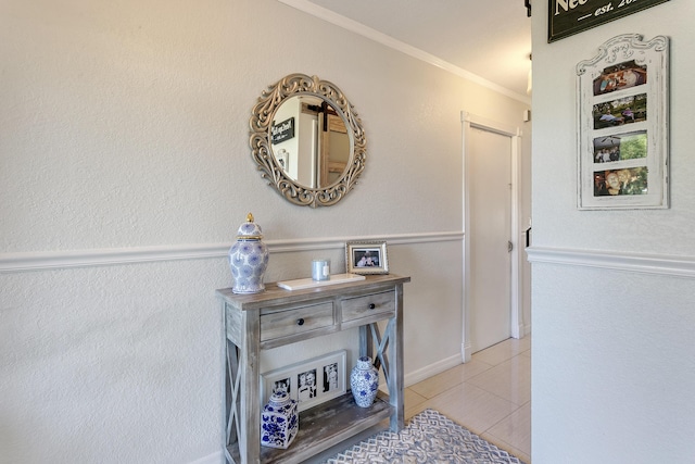 corridor featuring light tile patterned floors and crown molding