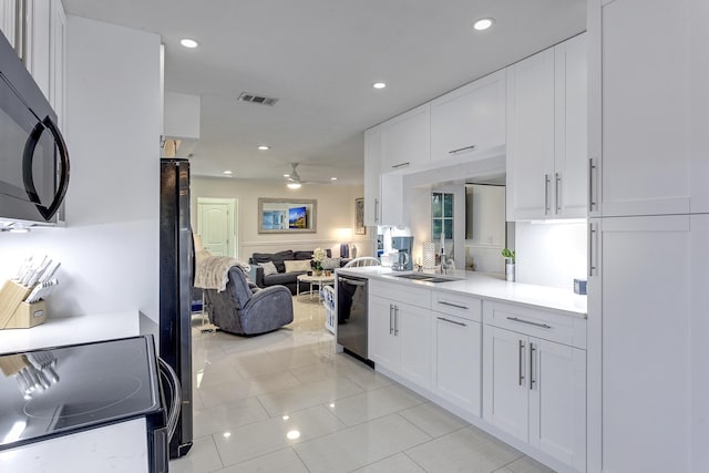 kitchen with visible vents, black appliances, ceiling fan, open floor plan, and white cabinetry