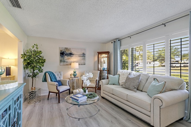 living room featuring visible vents, a textured ceiling, and wood finished floors