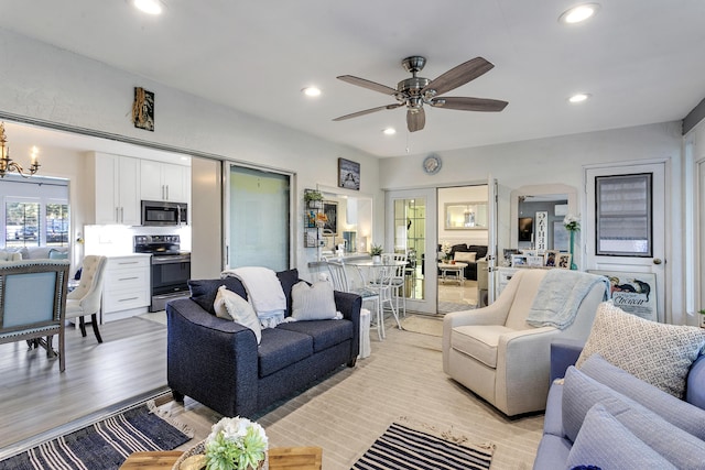 living room with ceiling fan with notable chandelier, recessed lighting, and light wood-type flooring
