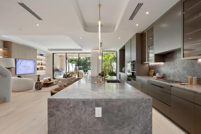 1246 George Bush, Delray Beach, FL 33483 - kitchen featuring visible vents, modern cabinets, stainless steel gas cooktop, a sink, and a raised ceiling