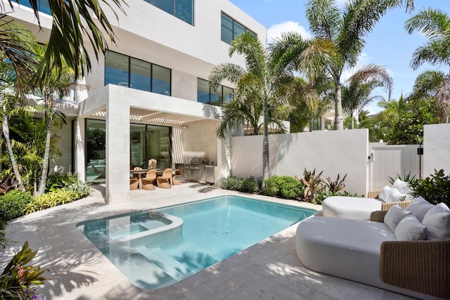 1246 George Bush, Delray Beach, FL 33483 - view of pool with fence, a pool with connected hot tub, an outdoor kitchen, a gate, and a patio area