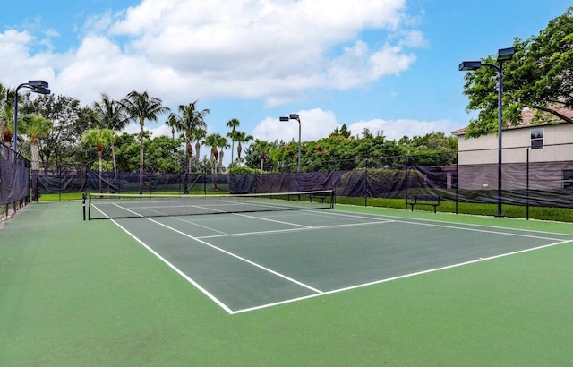 view of tennis court featuring fence and community basketball court