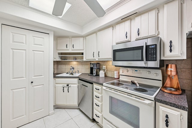 2400 Presidential Way Unit 302, West Palm Beach, FL 33401 - kitchen with stainless steel appliances, a sink, dark countertops, light tile patterned floors, and decorative backsplash