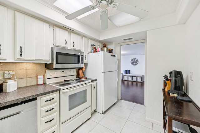2400 Presidential Way Unit 302, West Palm Beach, FL 33401 - kitchen featuring appliances with stainless steel finishes, dark countertops, light tile patterned floors, tasteful backsplash, and a ceiling fan