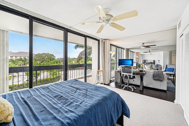 2400 Presidential Way Unit 302, West Palm Beach, FL 33401 - bedroom featuring access to outside, a desk, a wall of windows, a ceiling fan, and a textured ceiling